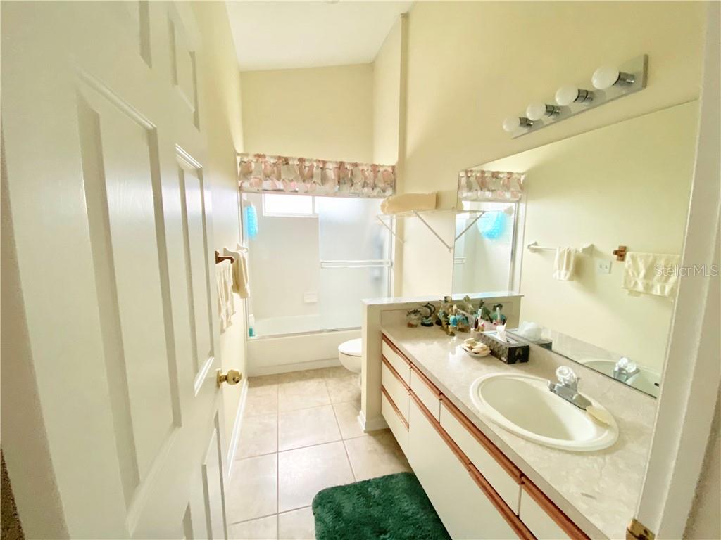 BEAUTIFUL TILE AND NEUTRAL COUNTERTOPS IN GUEST BATH