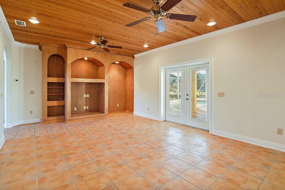 Living Room with custom woodwork in ceilings and built ins for entertainment area.  Featuring imported Spanish tiles.