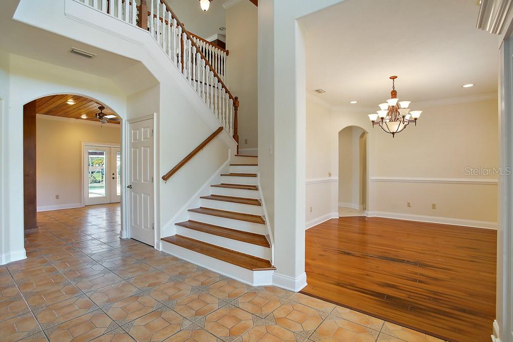 Front Foyer looking into Dining area / living area in rear.   Stairs leading up to family room with Balcony over looking pool and canal!