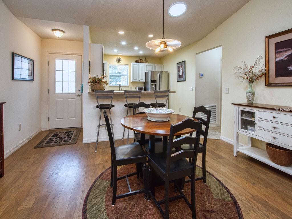 Dine on hardwood floors; view front door, kitchen, and hallway to garage