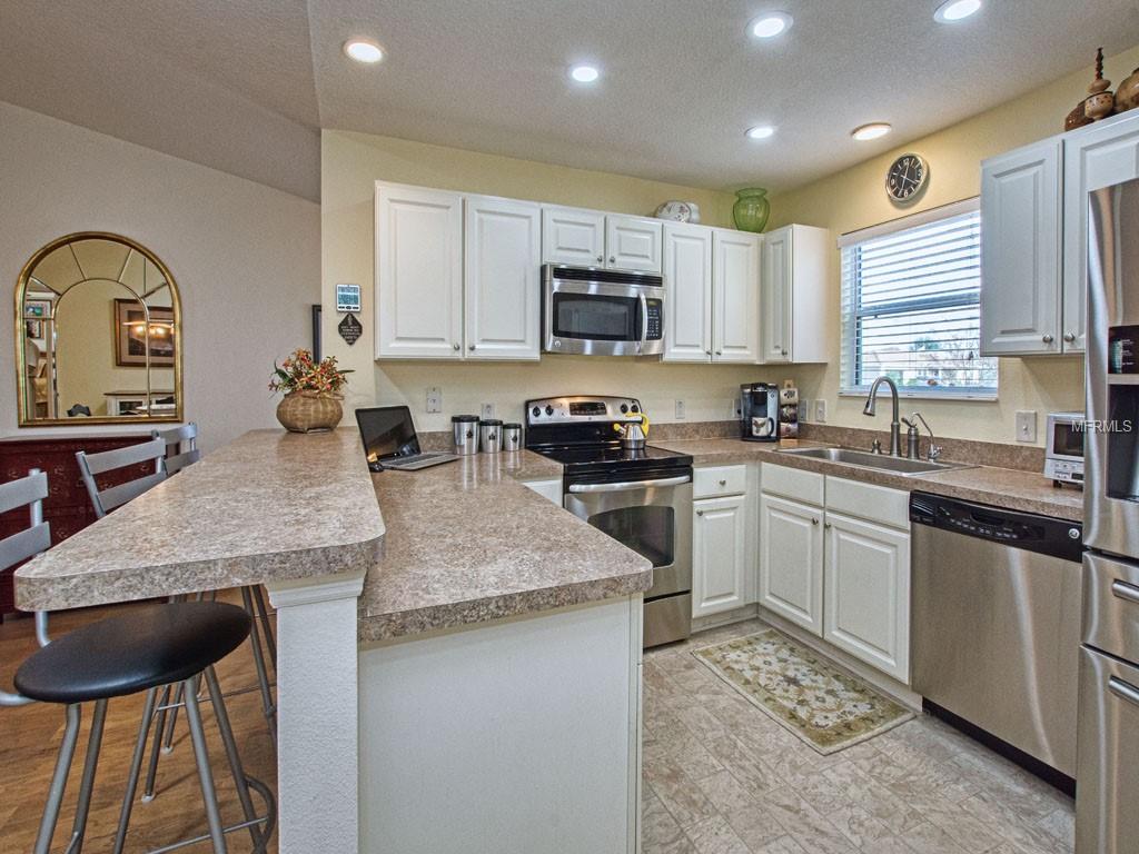 Cook with Stainless Steel appliances under brilliant recessed lights.