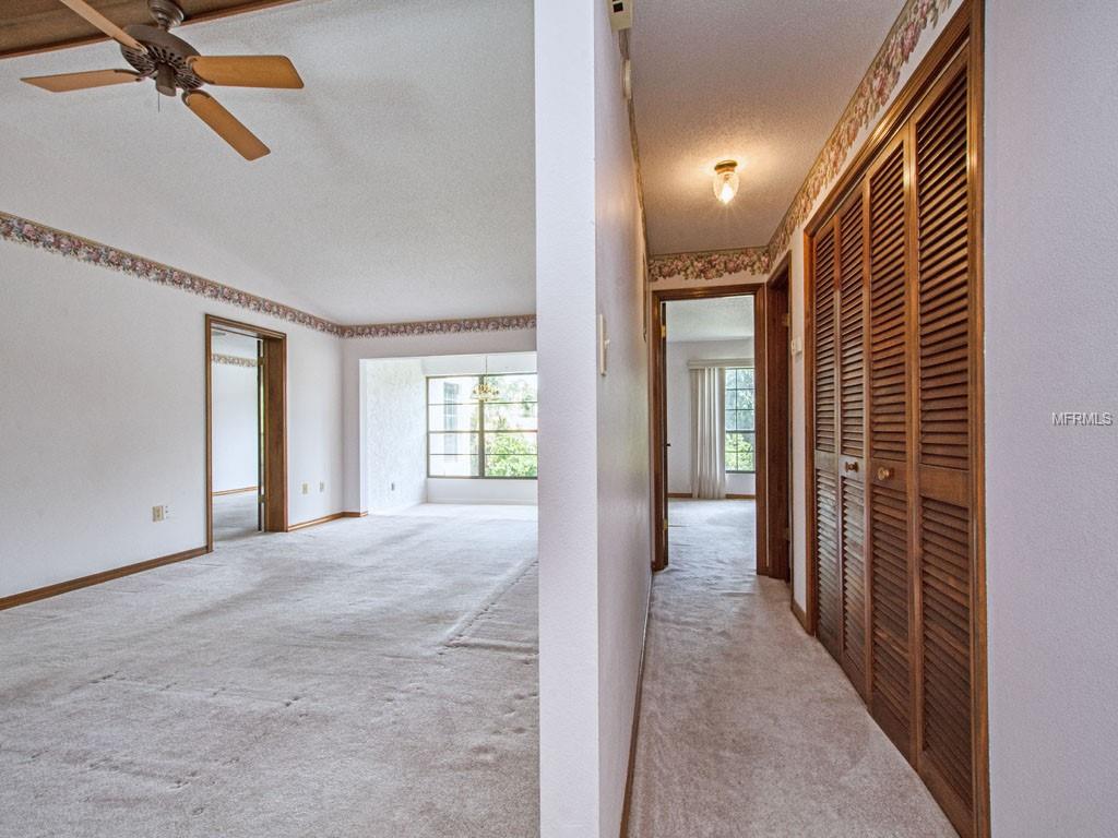 Hallway to 2nd Bedroom and Bath with storage and utility closets.