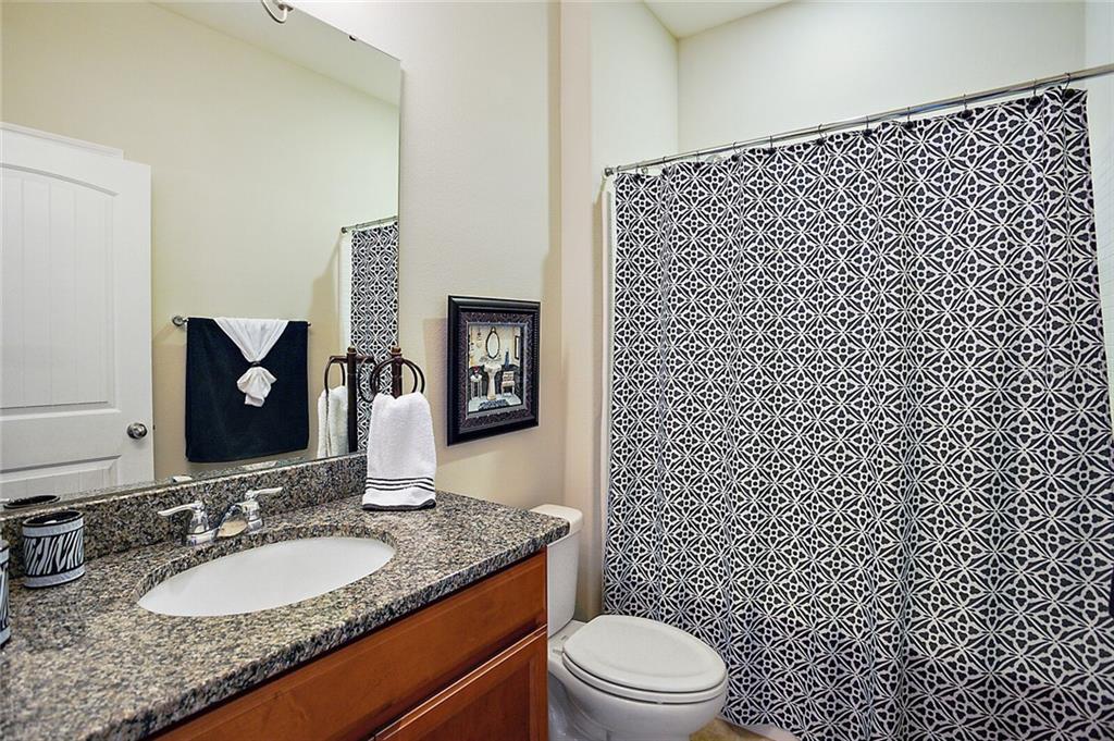 Bath #3 with granite counter tops, ceramic tile, and tub with shower.