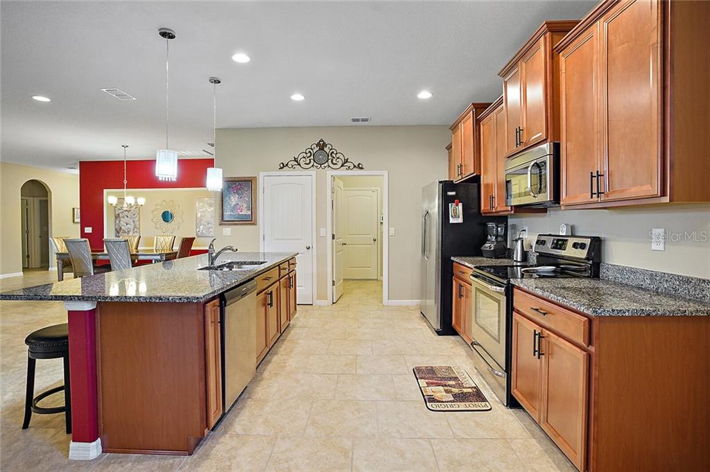 Come right on in to this designer chef's kitchen with Stainless Steel appliances, Granite Counter tops, Timberlake Cabinets with Crown Molding, and a flow through counter top island design. An ample walk-in pantry is ready for all your cooking and baking essentials.