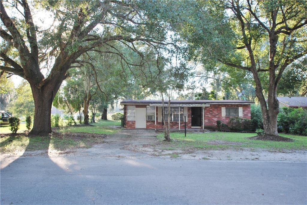 Beautiful red brick home shaded by wonderful mature trees