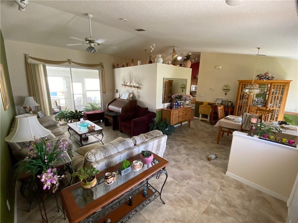 LIVING ROOM WITH DOOR TO LANAI/DINING ROOM WITH DOOR LEADING INTO KITCHEN