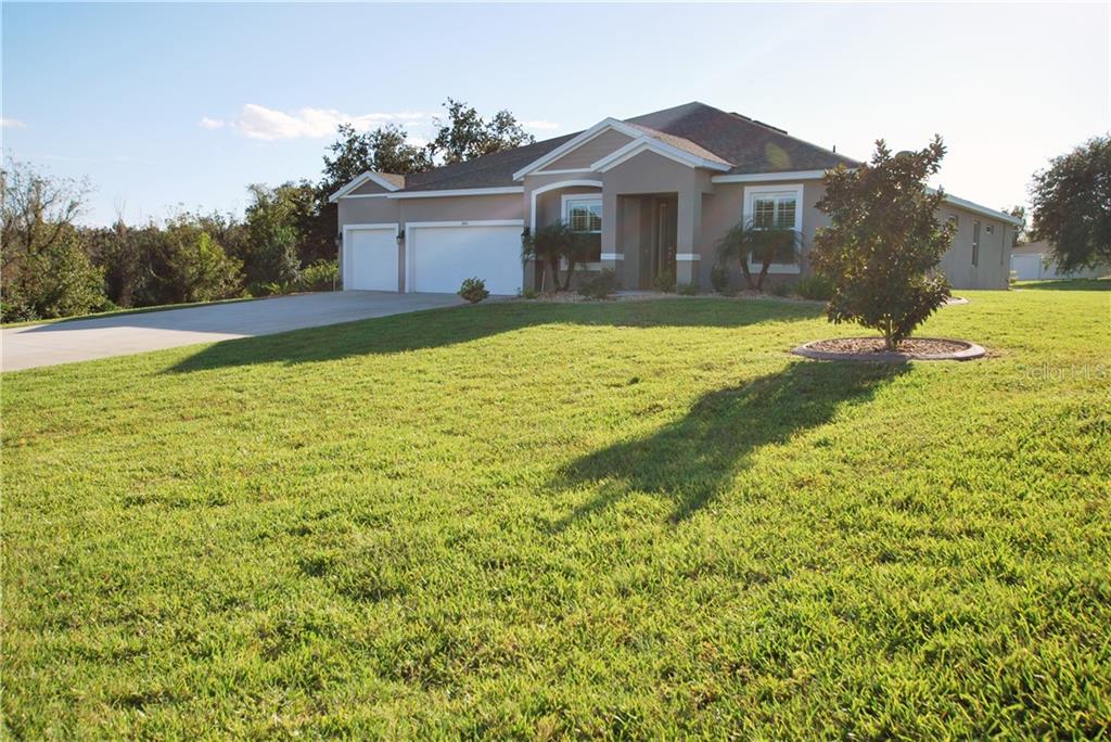 Professionally landscaped with concrete curbing around garden.