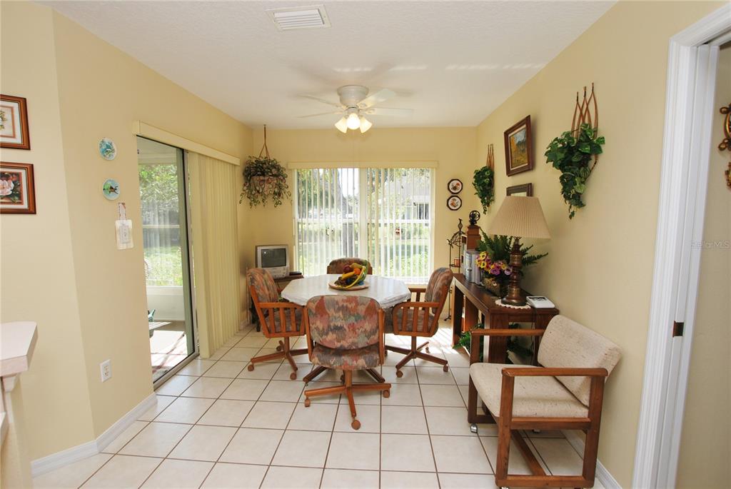 Eat-in area off kitchen with sliding door to enclosed lanai and view to lovely back yard.