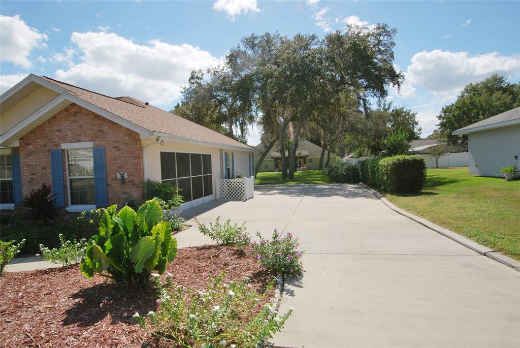 Driveway leading up to garage which has screen enclosure.
