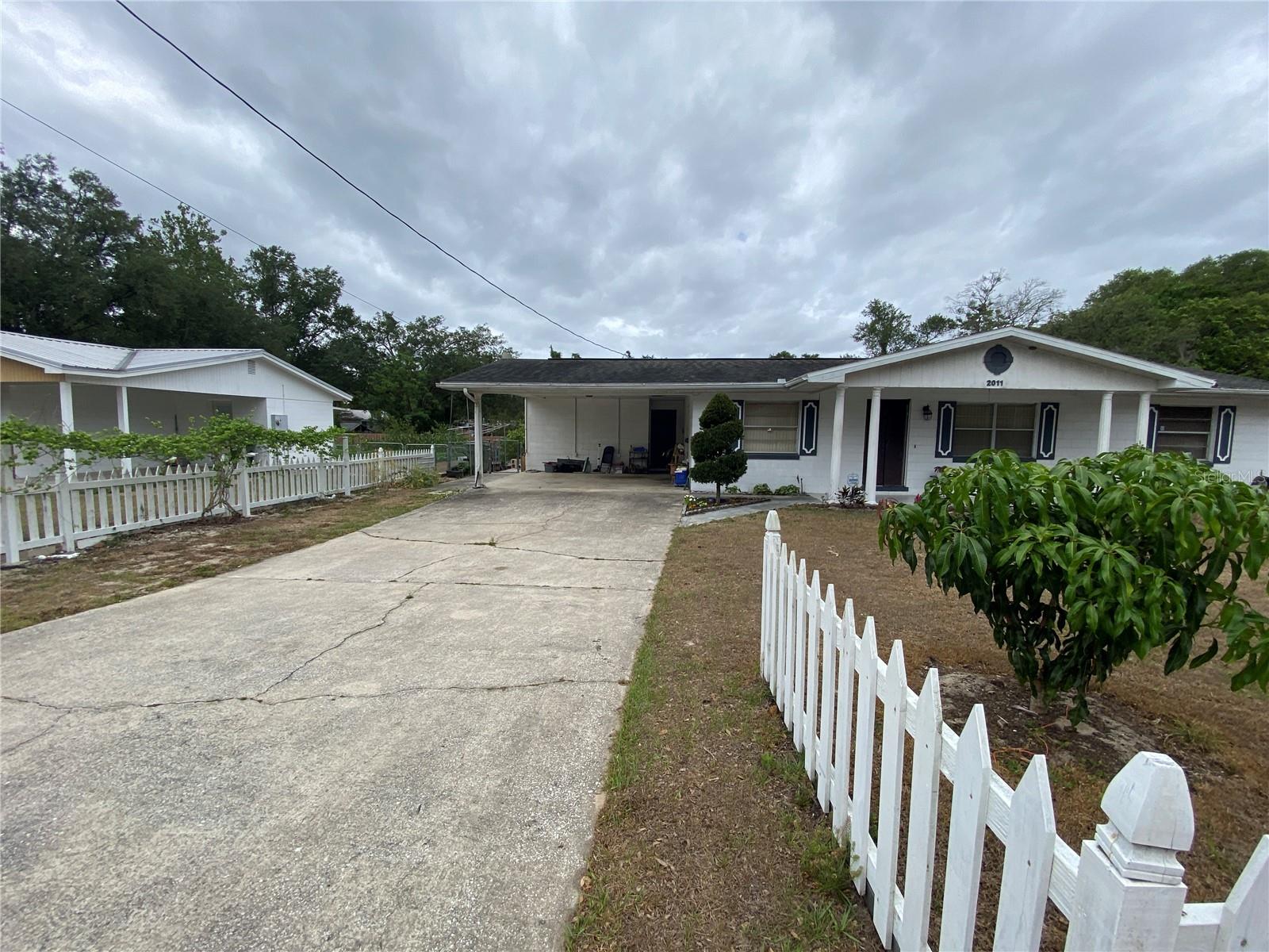 FRONT SHOWING FENCING, DRIVEWAY, AND FENCING