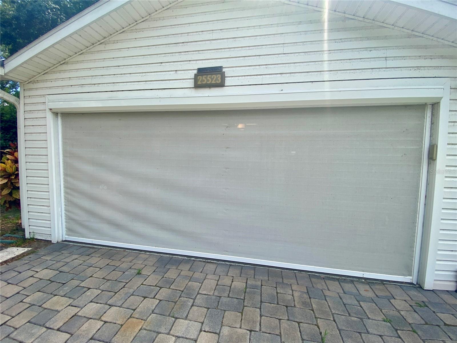 GARAGE SCREEN AND PAVERS IN DRIVEWAY