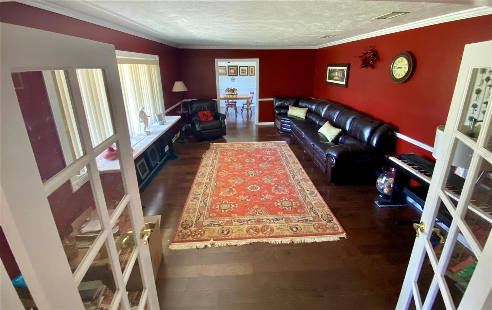 LIVING ROOM WITH ENGINEERED HARDWOOD FLOORS, CHAIR RAILING, AND CROWN MOLDING