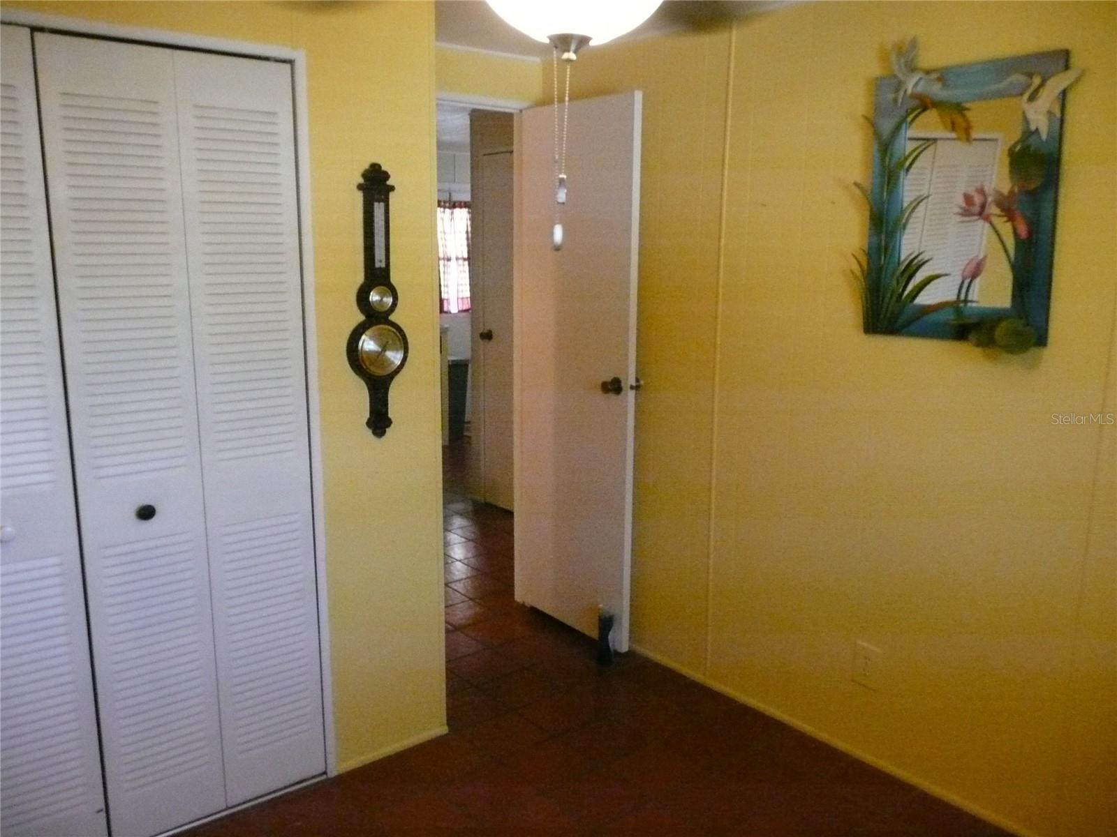 The Tile hallway from the Kitchen leads 1st to the Guest Bedroom