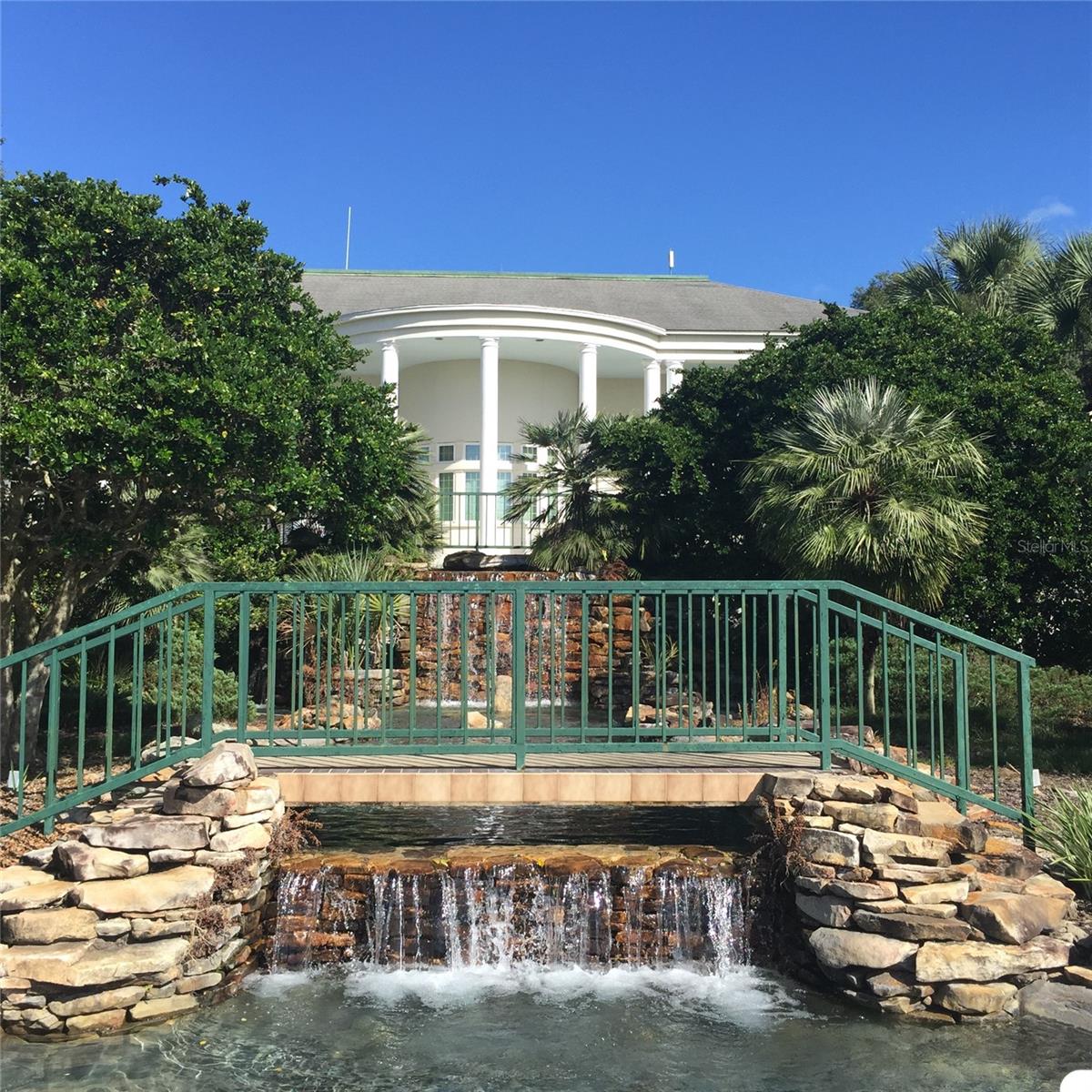 WATERFALL AT MANOR POOL AND REAR VIEW OF MANOR CLUBHOUSE