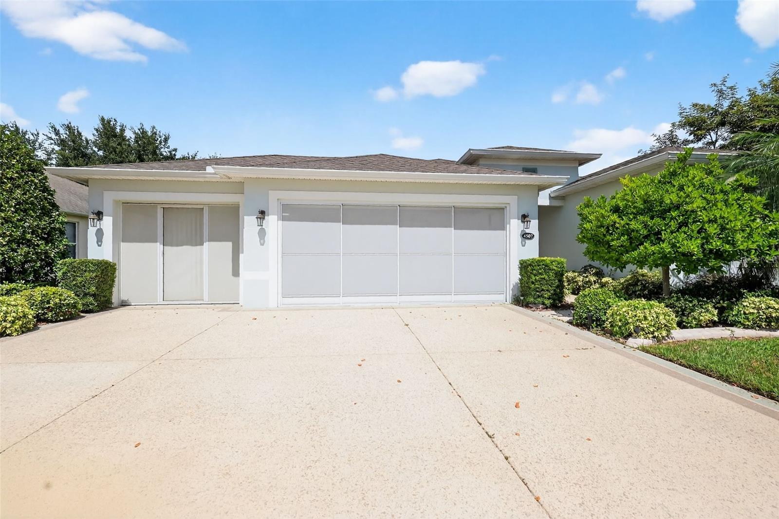 Front view with garage doors open and screens closed.