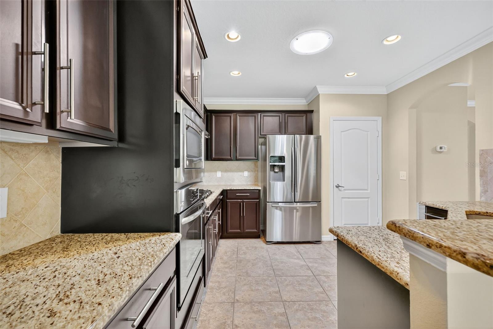 Kitchen featering built in oven and Microwave - gas countertop stove and double door refrig with botom freezer.